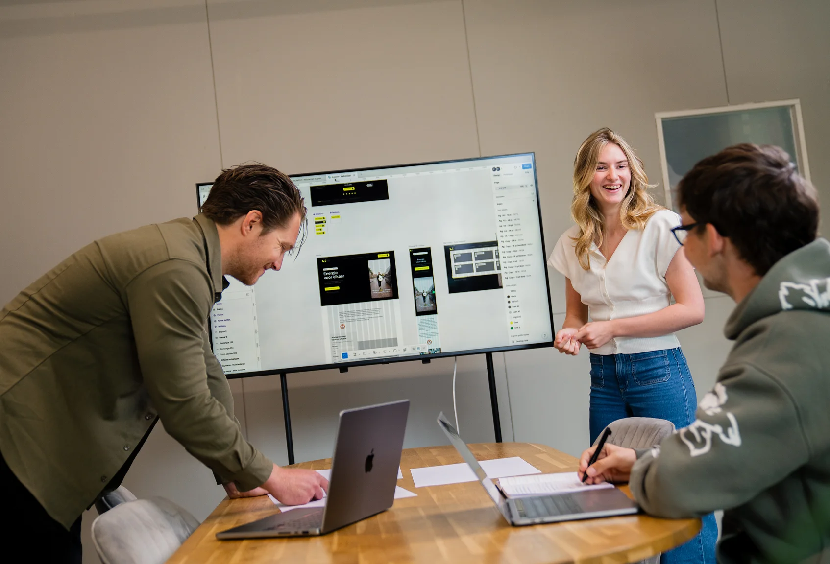 The BRANDBITS team is discussing an employer branding concept on a presentation screen.